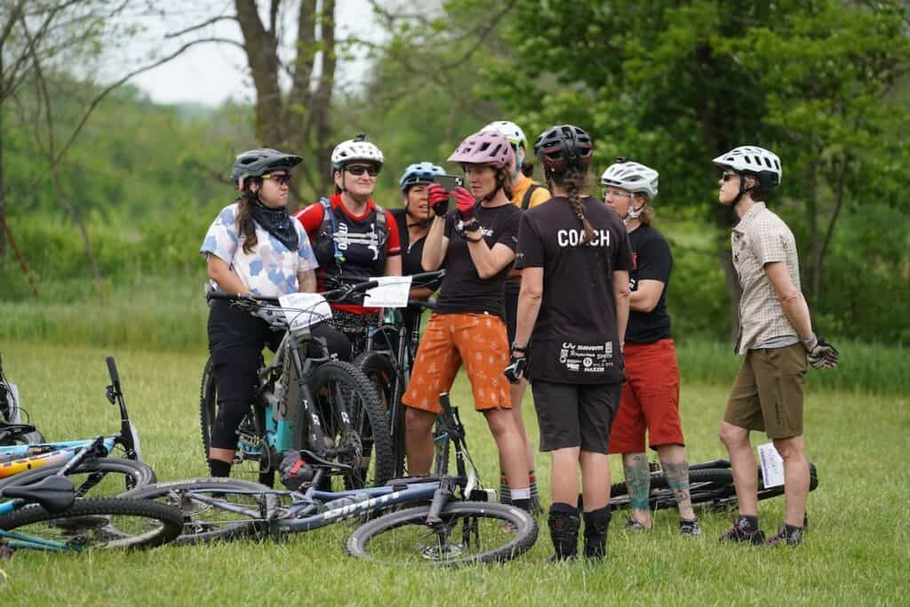 Mountain bike coach showing video on photo to camp participants