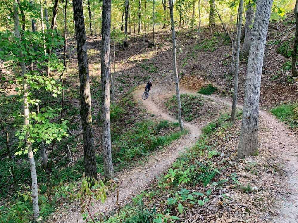 Mountain biker riding down switchback on singletrack trail in Bentonville, Arkansas