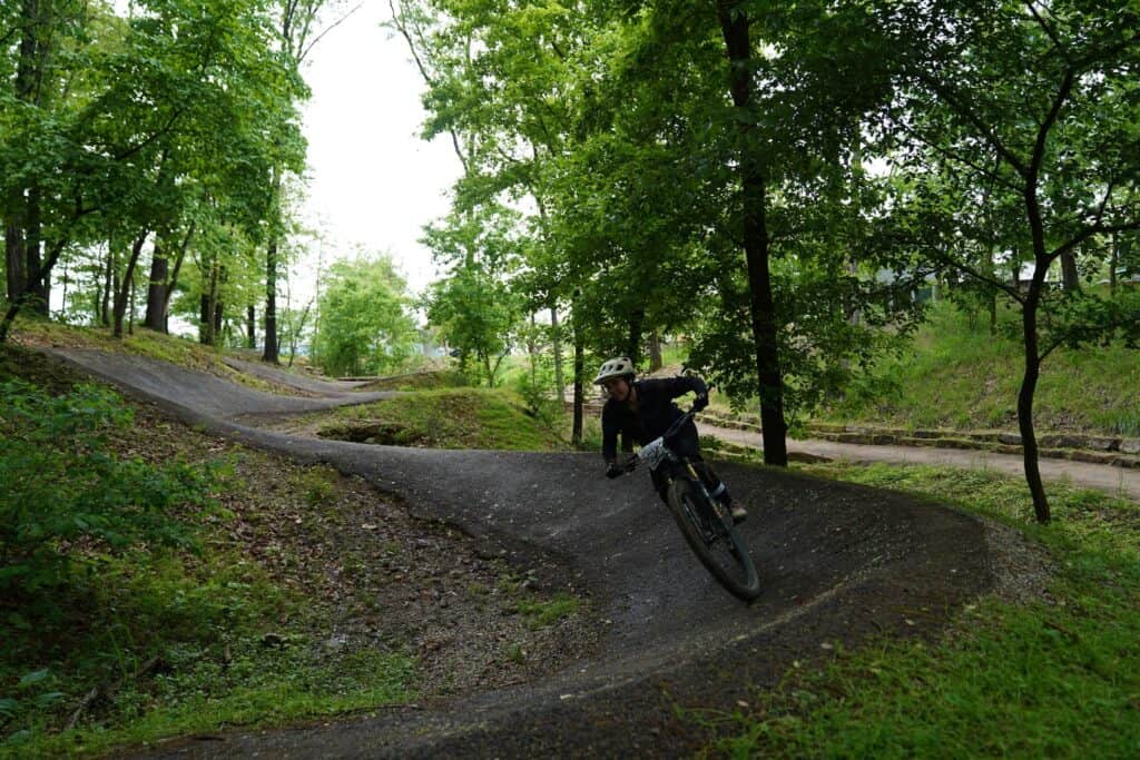 Mountain biker riding down paved bermed trail in Bentonville, Arkansas